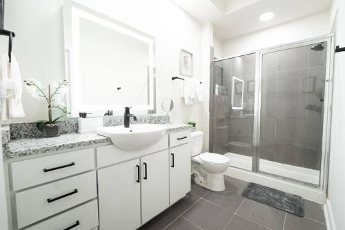 a white bathroom with a sink and a shower at Luxury Apartment WiFi, Gym, Pool, Shops & Food! Unit 329 in Charlotte