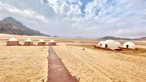 a group of tents in the middle of a desert at Rum Jordan camp and tours in Wadi Rum