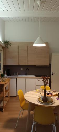 a kitchen with a table and yellow chairs in a room at à l´aise in Petit Mesnil