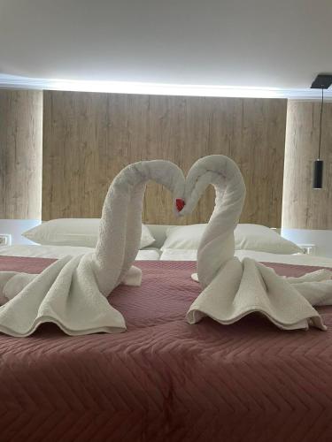 two swans making a heart shape on a bed at Hotel - Villa Lejla in Mostar