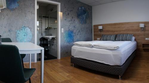 - une chambre avec un lit et une table ainsi qu'une salle de bains dans l'établissement Motel Arctic Wind, à Vogar