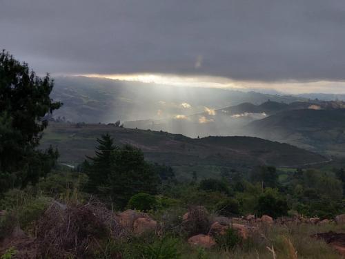 a view of a valley with the sun shining through the clouds at Monarca Azul Glamping in Villa de Leyva