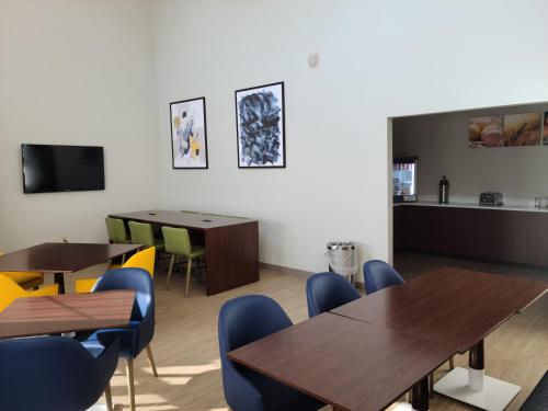 a dining room with wooden tables and blue chairs at Comfort Inn & Suites in Shelbyville