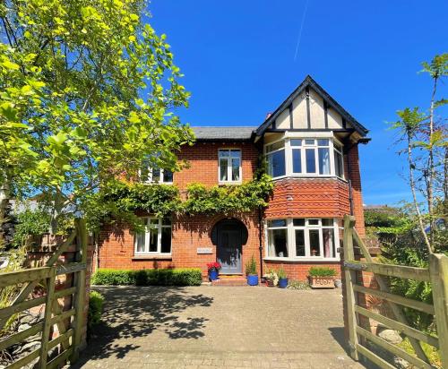 a brick house with a gate and a fence at Sunny Dale in Niton