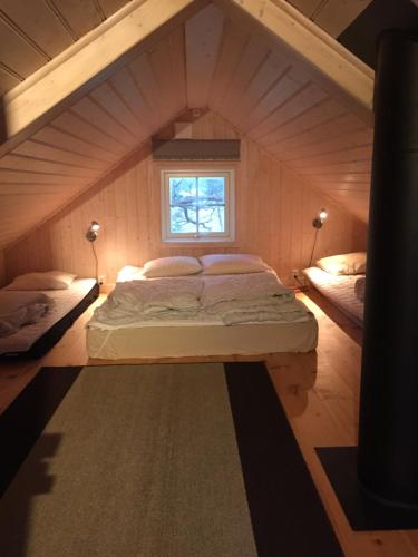 uma cama num pequeno quarto com uma janela em Stuga vid viltåker nära norska gränsen em Strömstad