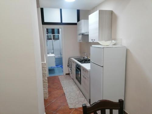 een keuken met een witte koelkast en een fornuis bij CaSa AMELIA in Napels