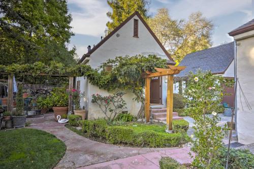 a small white house with a garden in front of it at Updated Menlo Park English Tudor Garden Cottage! in Menlo Park