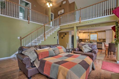 a living room with a couch and a staircase at Hot Tub and Wooded Views Lakefront Blue Eye Cottage in Blue Eye
