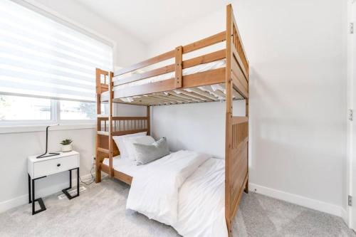 埃德蒙顿Modern Nordic Escape, 3BR Near WEM & DT, AirCon & Fireplace, Wifi, Sleeps 6!的一间带双层床和书桌的卧室