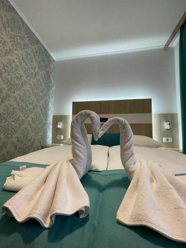 two towel swans sitting on top of a bed at Hotel - Villa Lejla in Mostar