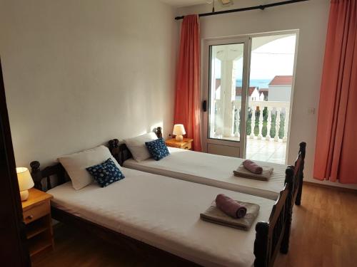 dwa łóżka w pokoju z dużym oknem w obiekcie Apartments Dodik w Orebiciu