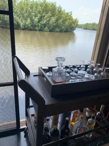 Ouidah的住宿－Dolce Ouidah Lodge，一张桌子,从窗口可欣赏到河流美景
