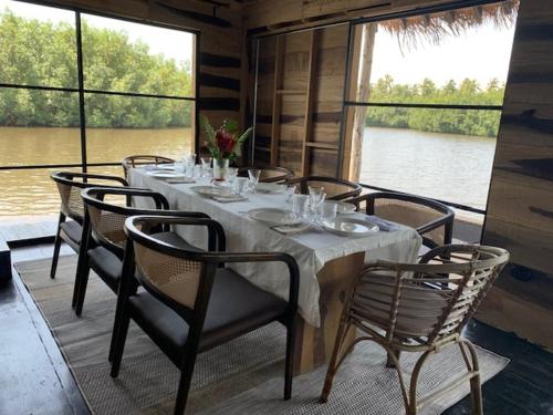 una sala da pranzo con tavolo e sedie su una barca di Dolce Ouidah Lodge a Ouidah
