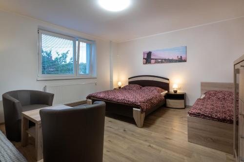 sypialnia z 2 łóżkami, krzesłem i oknem w obiekcie StoneMlynska 7 Slovakia w Świcie