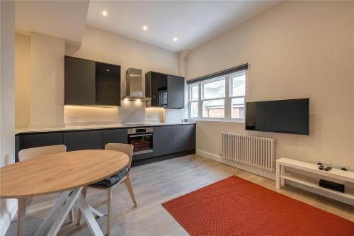 a kitchen with a wooden table and a dining room at Apartments in the heart of Richmond, London in Richmond upon Thames