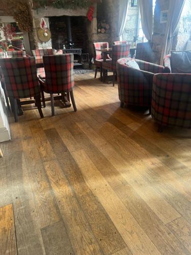 a room with chairs and a table and a fireplace at Coach and Horses INN in Penzance