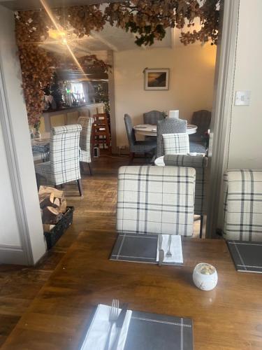 een woonkamer met stoelen en een tafel en een eetkamer bij Coach and Horses INN in Penzance