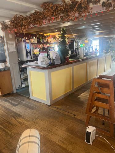 un bar con barra y taburete de madera en Coach and Horses INN en Penzance