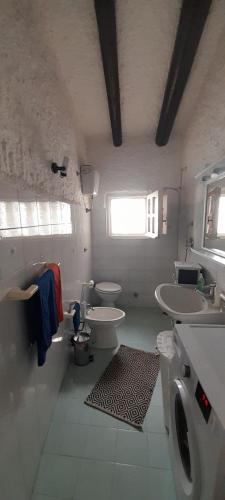 a bathroom with two toilets and two sinks and a window at ViaGramsci129 in San Teodoro