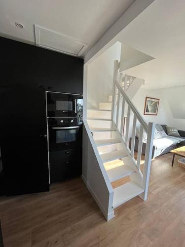 - un escalier blanc dans un salon avec une cuisine dans l'établissement Appartement T2 - port d'Orange, à Saint-Pierre-Quiberon