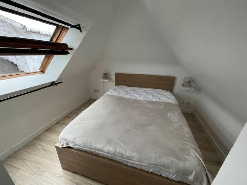 Bett in einem kleinen Zimmer mit Fenster in der Unterkunft Appartement T2 - port d'Orange in Saint-Pierre-Quiberon