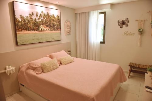 a bedroom with a bed with a picture on the wall at CARNEIROS BEACH RESORT AP 311 E in Praia dos Carneiros