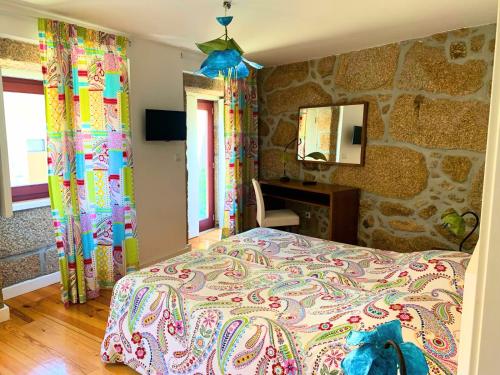 1 dormitorio con cama y pared de piedra en Casas d Aldeia Turismo Rural, en Mangualde