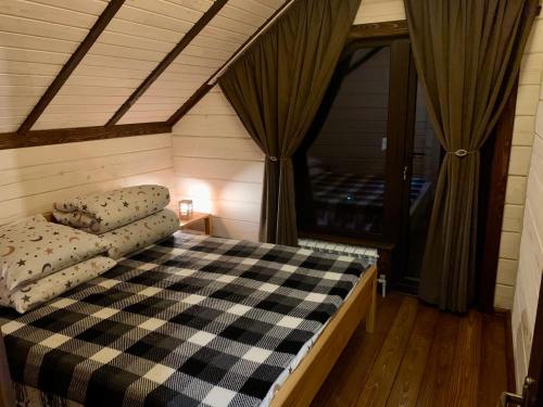 1 dormitorio con cama a cuadros en una casa en Еко будинок в горах, en Verkhniy Bystryy