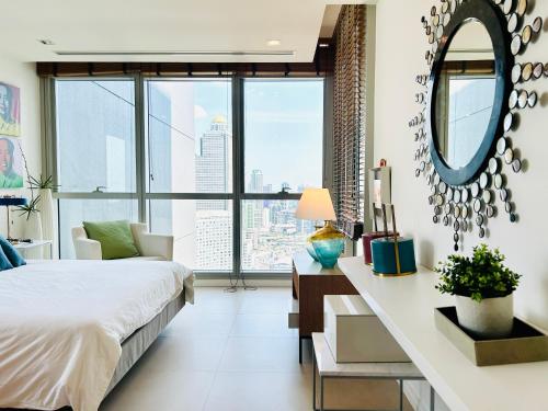 a bedroom with a bed and a desk with a mirror at The river luxury two bedrooms in Bangkok