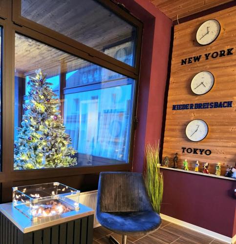 a room with a christmas tree and clocks on the wall at Niederdreisbacher Hof in Niederdreisbach