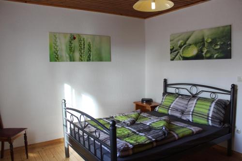 Bett in einem Zimmer mit zwei Bildern an der Wand in der Unterkunft Ferienwohnung an der Hundem in Kirchhundem