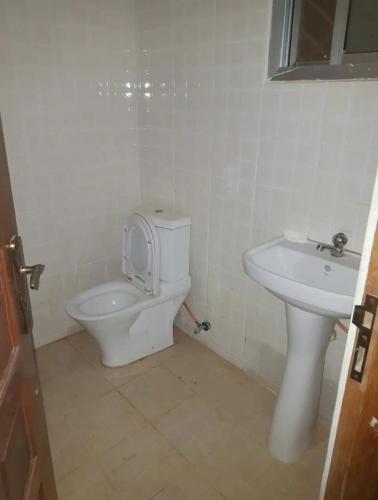 uma casa de banho com um WC e um lavatório em Dutchlond Rooms em Freetown