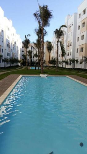 a large swimming pool in front of some buildings at Appartement dans résidence privée avec piscine in Tamaris