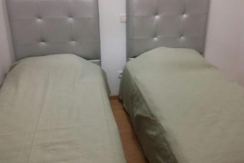 two beds sitting next to each other in a room at Appartement dans résidence privée avec piscine in Tamaris