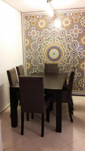ein Esszimmer mit einem schwarzen Tisch und Stühlen in der Unterkunft Appartement dans résidence privée avec piscine in Tamaris