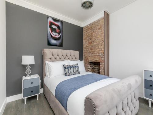 ein Schlafzimmer mit einem großen Bett und einer Ziegelwand in der Unterkunft Your Central Stay 5 bedroom flat in Brighton & Hove