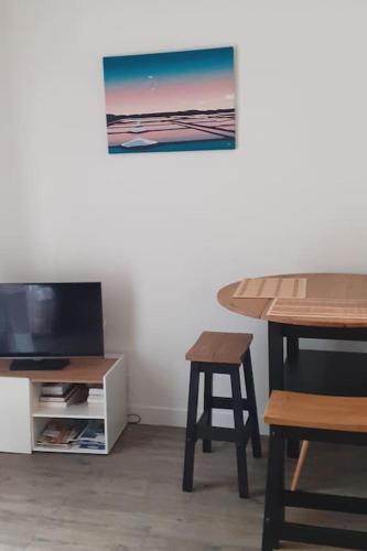 - un salon avec une table et un tabouret dans l'établissement Studio au calme à 400 m de la plage., à Pornichet