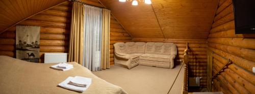 Habitación con 1 cama y 1 silla en una cabaña en Mini Hotel Laplandiya en Bukovel