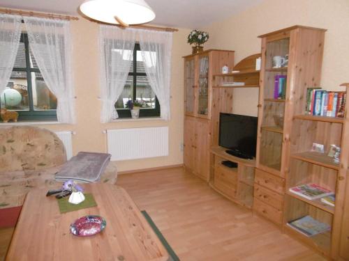 a living room with a wooden table and a tv at Ruegen_Fewo 33_2 in Gingst