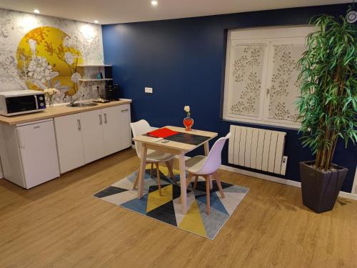 une cuisine avec une table et des chaises dans une pièce dans l'établissement Love Story Chalet avec jacuzzi et sauna, à Criquebeuf-sur-Seine