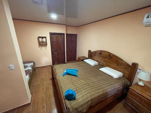 a bedroom with a bed with a blue bag on it at Ceiba lodge in Drake