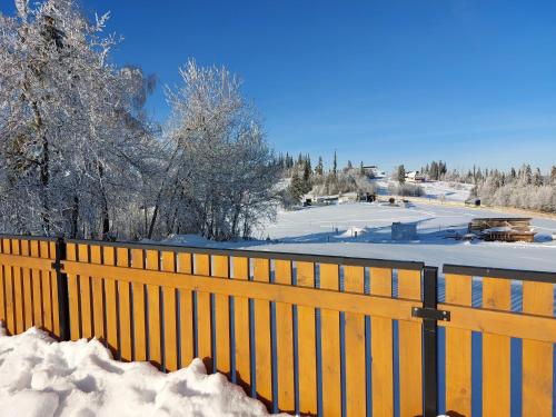 a fence covered in snow next to a snow covered slope at Domki na Wierchu - z widokiem na góry in Białka Tatrzanska