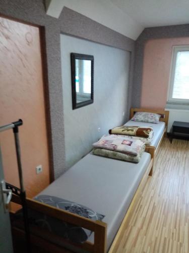 a room with two beds and a mirror at Prenociste DUGA in Užice