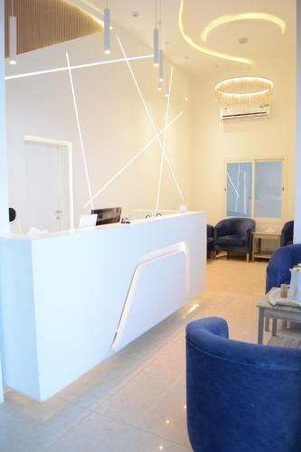 a waiting room with blue chairs and a counter at بيت الماس للشقق الفندقية MAAS House Apartments in Abha