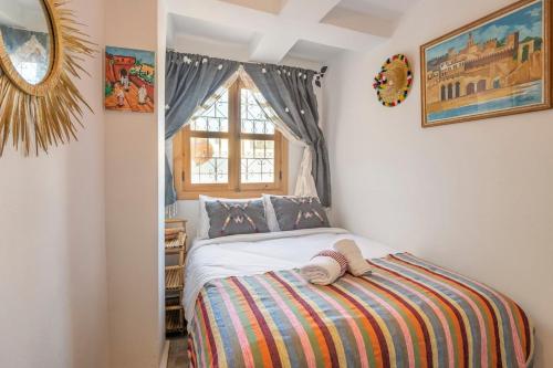a bedroom with a bed and a window at Dar BAB HAHA Petite Maison à la Marocaine in Tangier
