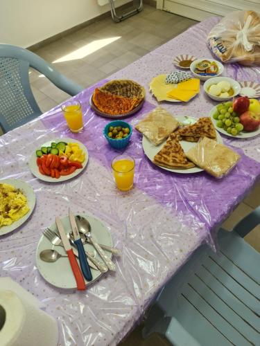 een paarse tafel met borden eten erop bij Vida Bhermon 2, one small wooden cabin in Majdal Shams