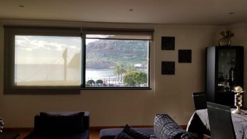 a room with a window with a view of the ocean at VIP Paradise Apartment in Machico