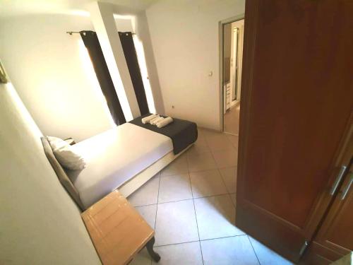 a small bedroom with a bed and a chair at Villa Alba Apartments in Dobra Voda