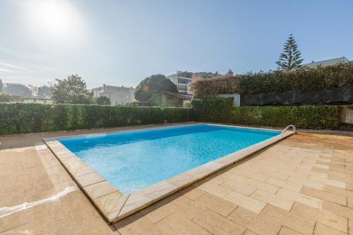 a large swimming pool in a yard with a brick patio at Penthouse Praia de Olinda - Minho's Guest in Vila do Conde