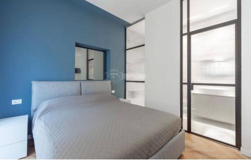een slaapkamer met een wit bed en een blauwe muur bij Milano - delizioso appartamento in pieno centro. Fancy yellow apartments in Milaan